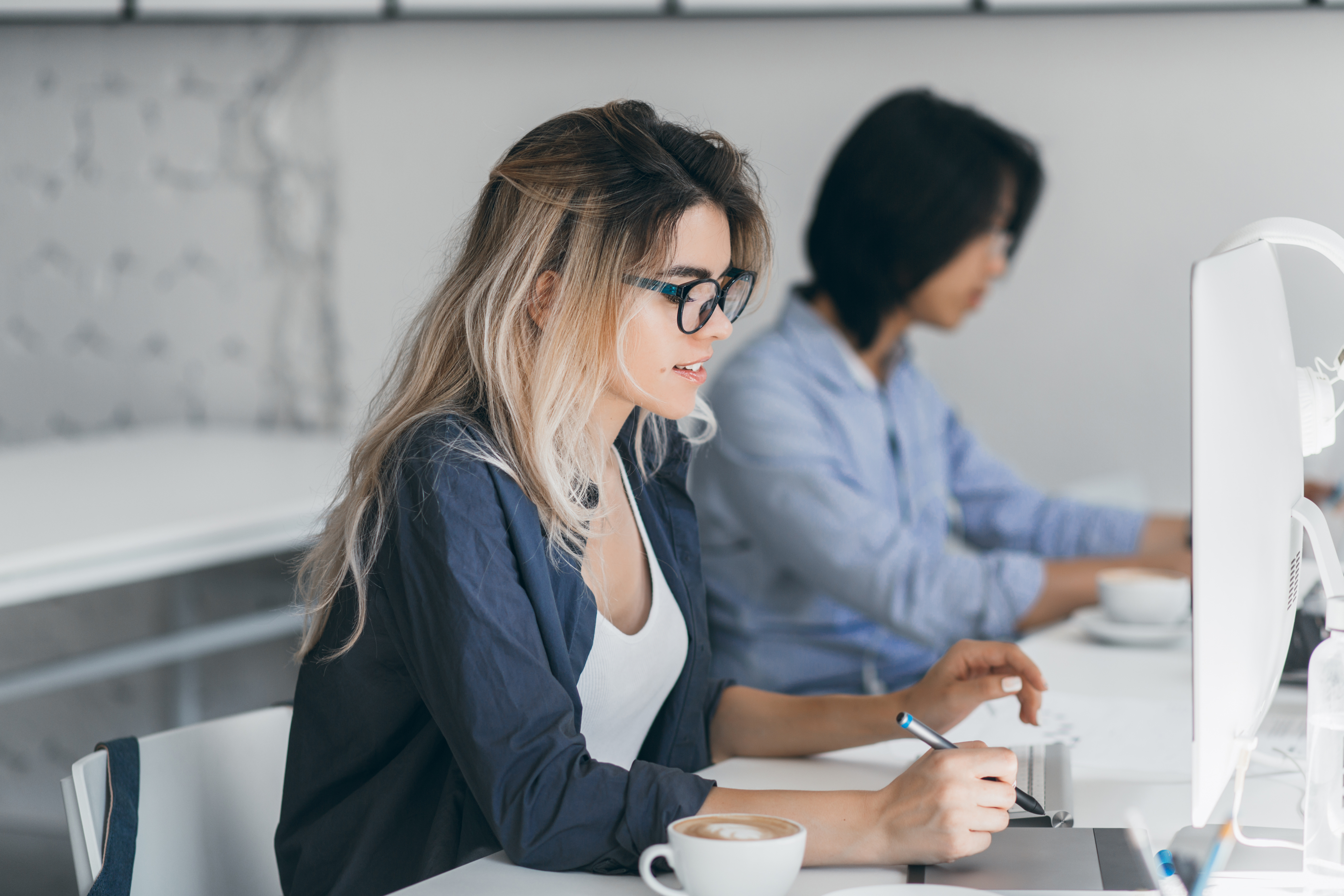 Professional women working on a computer at a desk. 