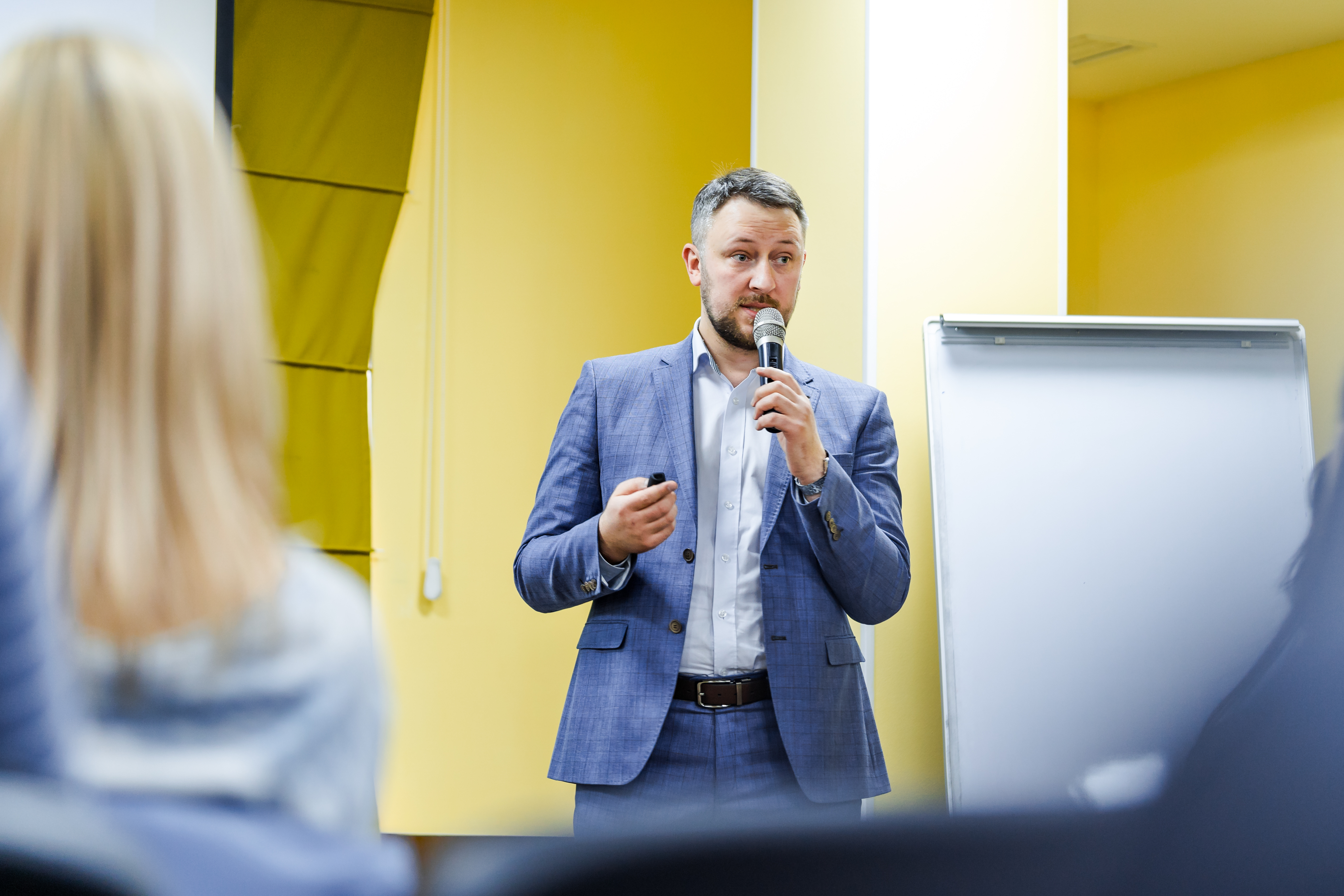 A businessman holding a microphone giving a presentation.